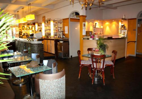 un restaurant avec des tables et des chaises et un bar dans l'établissement Hôtel Bar Aux Armes D'Estaing - KB HOTEL GROUP, à Estaing