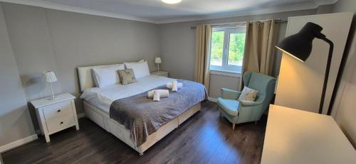 a bedroom with a bed and a chair and a lamp at Holyrood House in Edinburgh