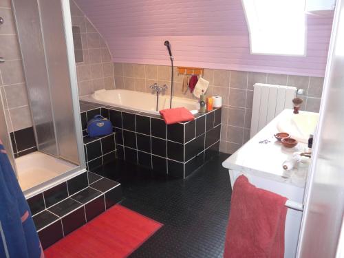 La salle de bains est pourvue d'une baignoire, d'une douche et d'un lavabo. dans l'établissement Gite Les Sources, à Marcillac-la-Croisille