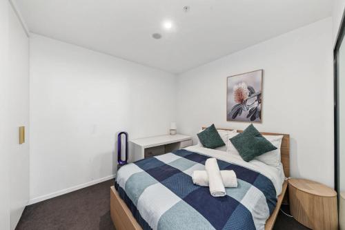 a bedroom with a bed with a blue and white striped blanket at 2BR-1BR-1Car- CBD Pool Central in Canberra