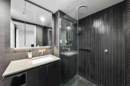 a bathroom with a shower and a sink and a mirror at 2BR-1BR-1Car- CBD Pool Central in Canberra