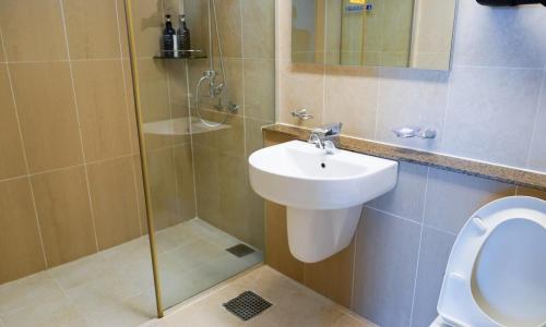 a bathroom with a toilet and a sink and a shower at Sagewood Yeosu Gyeongdo Resort in Kyŏngho-dong