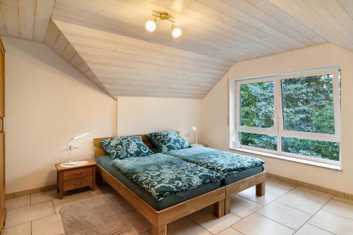 a bedroom with a bed and a window at Ferienwohnung "Am Hennenberg" in Erlenmoos