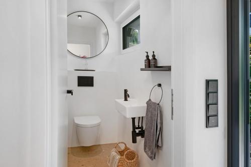a white bathroom with a sink and a toilet at Modern House, Pool, Garden in Burgdorf