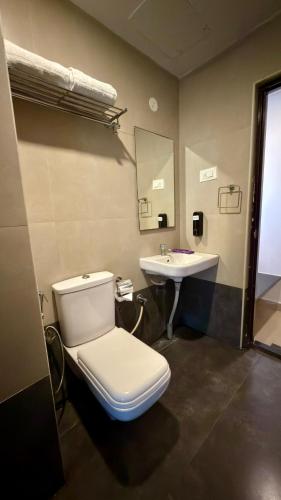 a bathroom with a toilet and a sink at Astra Hotels and Suites HSR Sector 1 in Bangalore