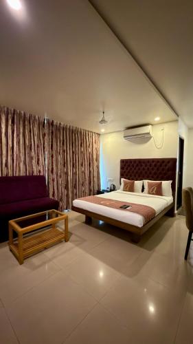 a bedroom with a large bed and a couch at Astra Hotels and Suites HSR Sector 1 in Bangalore