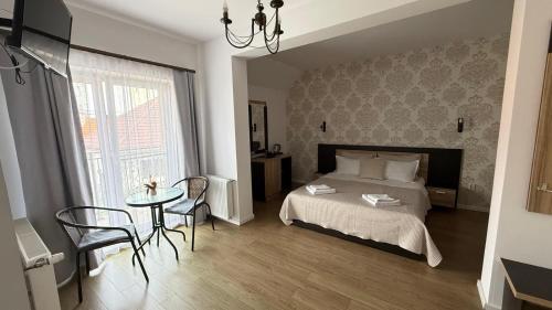 ein Schlafzimmer mit einem Bett und einem Tisch mit Stühlen in der Unterkunft Casa Mindru in Topliţa