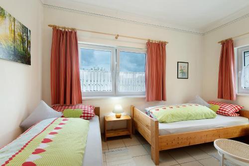 a bedroom with two beds and a window at Gemütliches 3-Sterne Ferienhaus in Zwiesel