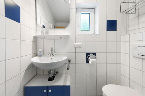 a white bathroom with a sink and a toilet at Gemütliches 3-Sterne Ferienhaus in Zwiesel