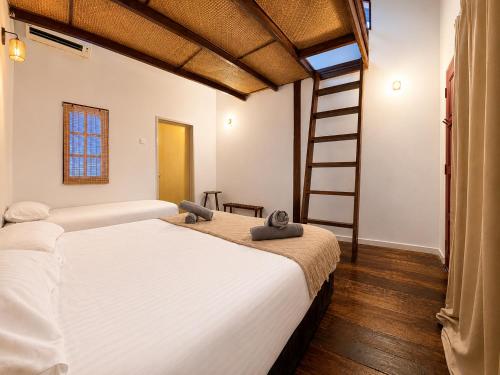 a bedroom with a large bed and a ladder at Redang Divers Resort in Redang Island