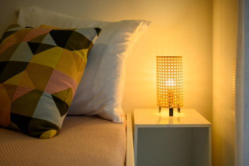 a bed with a pillow and a lamp on a table at Viktor 1 - Studio Hyper Centre - Place Jean Jaurès in Tours