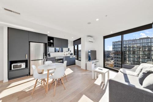 a kitchen and living room with a table and chairs at 1BR-1BR-1Car-Sleeps 4-Pool-CBD in Canberra