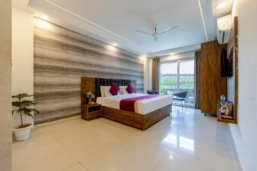 a hotel room with a bed and a large window at Soothing Stayz - Near Medanta The Medicity in Gurgaon