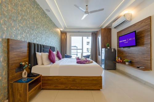a bedroom with a bed and a tv on a wall at Soothing Stayz - Near Medanta The Medicity in Gurgaon