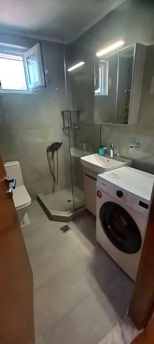 a bathroom with a washing machine and a sink at Georgia's house in Maronia