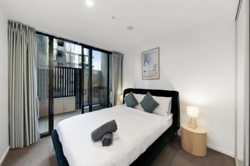 a bedroom with a bed and a large window at 2B-1BR-1Car-Courtyard-CBD-Shops in Canberra