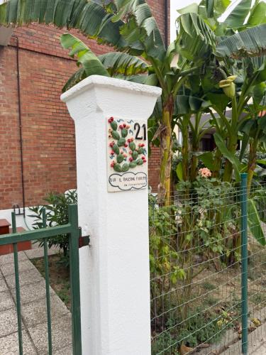 a white post with a sign on it next to a fence at B&B Il Balcone Fiorito in Imola