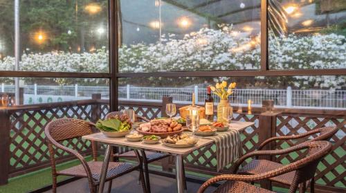 a table with a plate of food on a balcony at Gapyeong Dangdangi Pet Poolvilla Blue in Gapyeong