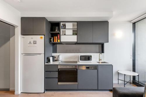 a kitchen with stainless steel appliances and a refrigerator at Central CBD - parking - sleeps 4 in Canberra