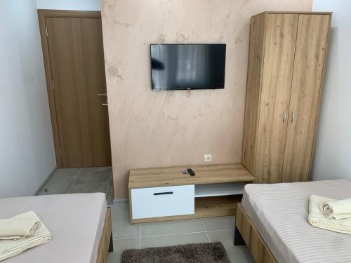 a room with two beds and a television on a wall at Eliksir in Gornja Trepča
