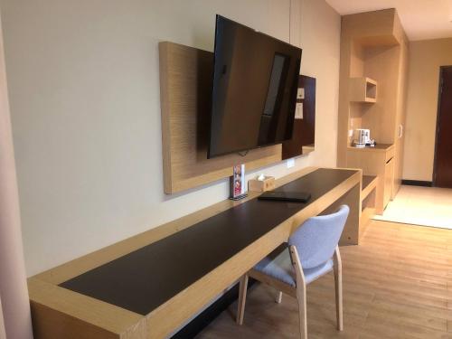 a desk with a tv and a chair in a room at Hotel Langkasuka Langkawi in Kuah