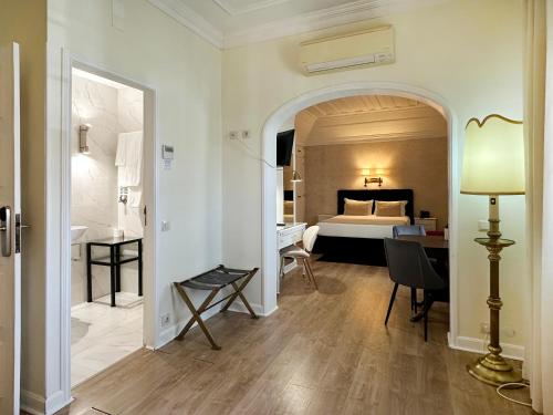a hotel room with a bed and a desk and a lamp at Hotel Joao Padeiro in Aveiro