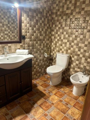 a bathroom with a sink and a toilet and a mirror at Adosado con piscina y parking in Benicàssim