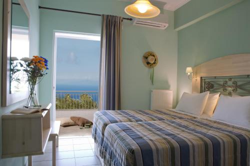 a bedroom with a bed and a view of the ocean at Amalia Apartments in Exanthia