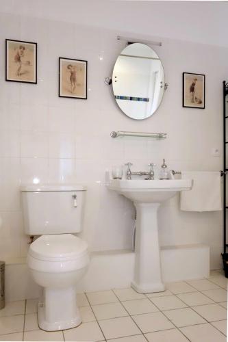 a white bathroom with a toilet and a sink at Chambre D'Hôtes le Phenix in Saint-Martin-du-Vivier