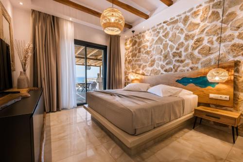 a bedroom with a bed and a stone wall at Naxos Royal Villas in Stelida
