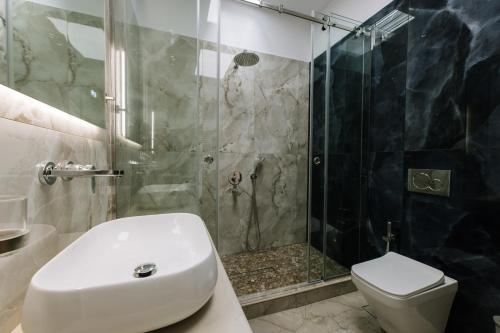 a bathroom with a shower and a toilet and a sink at Naxos Royal Villas in Stelida