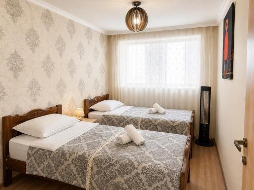 a room with two beds and a window at Mestia Central Apartment in Mestia