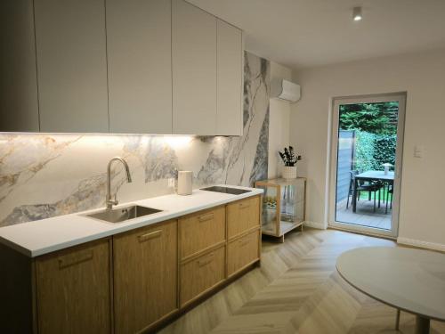 a kitchen with a sink and a table in it at Apartt99 Łeba in Łeba