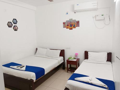two beds in a room with white walls at De Township beach in Pondicherry