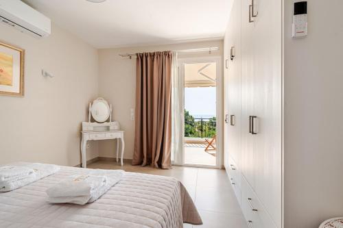 a white bedroom with a bed and a mirror at GAIAeMARE Suit Apartment in Pesádha