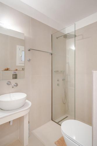 a white bathroom with a sink and a shower at GAIAeMARE Suit Apartment in Pesádha