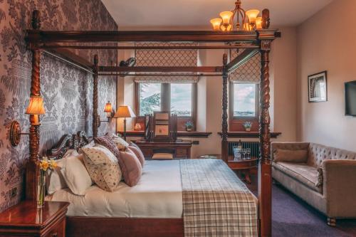 ein Schlafzimmer mit Himmelbett und Sofa in der Unterkunft Stanbrook Abbey Hotel, Worcester in Worcester