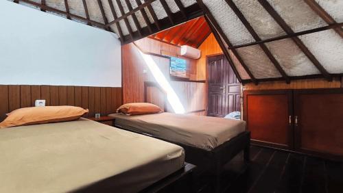a bedroom with two beds in a small room at Eimas Hive in Kerobokan