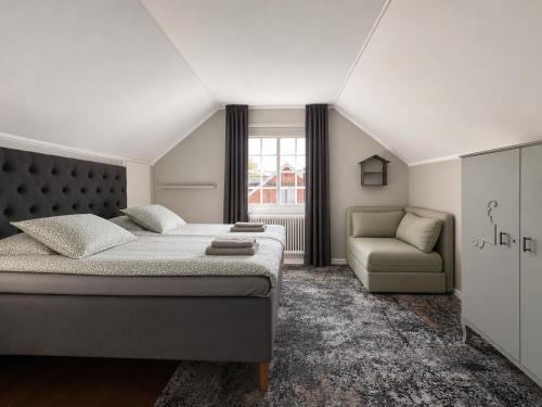 a bedroom with a bed and a couch and a window at Villa Bergåsa in Karlskrona
