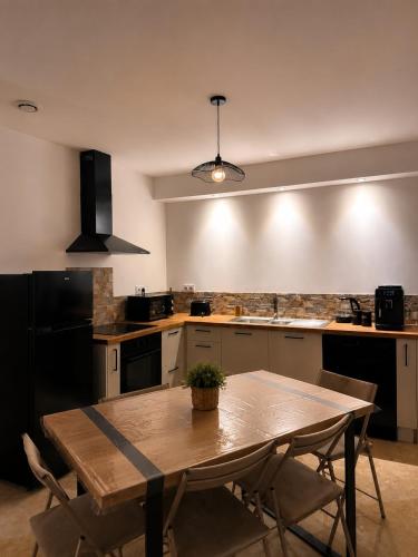 a kitchen with a wooden table with chairs and a tableablish at Coin détente in Vierzon