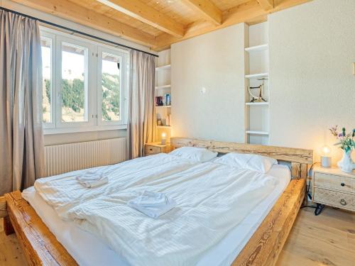 a large bed in a room with a window at Luxury Alpine Chalet with incredible Views in Lenk