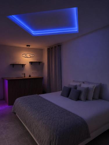 a bedroom with a large bed with a blue light at Coin détente in Vierzon