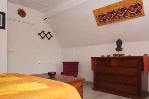 a bedroom with a bed and a dresser and a chair at Chambre D'Hôtes le Phenix in Saint-Martin-du-Vivier