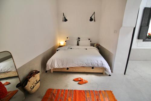 a small bedroom with a bed and a mirror at Riad Sahara - Private House Rooftop Medina Marrakech in Marrakesh