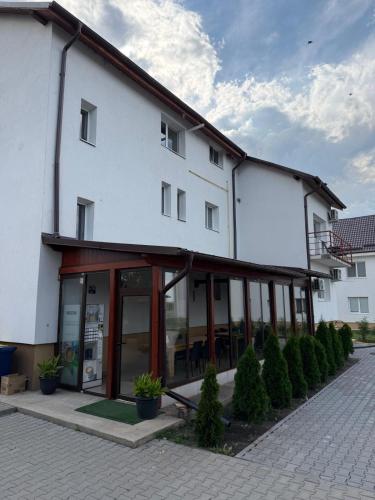 a large white building with glass windows and plants at La Luna Imobiliare in Ocna-Mureşului