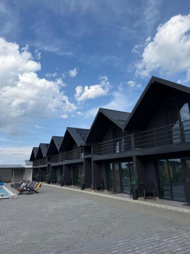 a building with black roofs and a swimming pool at La Luna Imobiliare in Ocna-Mureşului