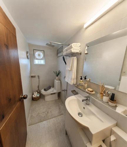 a bathroom with a sink and a toilet and a mirror at Royal Richmond Hotel in Dhaka