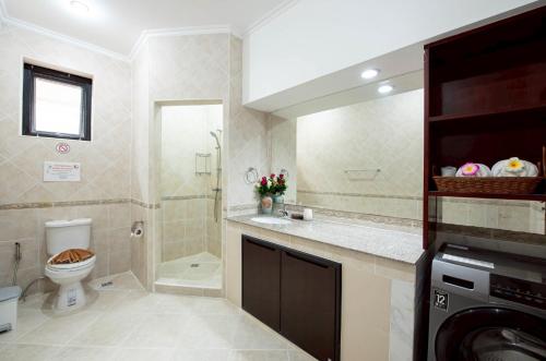 a bathroom with a toilet and a sink and a washing machine at MM Pool Villa in Pattaya South