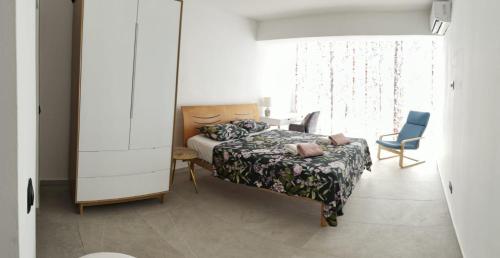 a bedroom with a bed and a chair and a window at Rose in Portorož