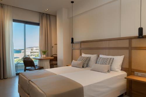 a bedroom with a large bed and a balcony at Elpis Studio Apartments in Bali